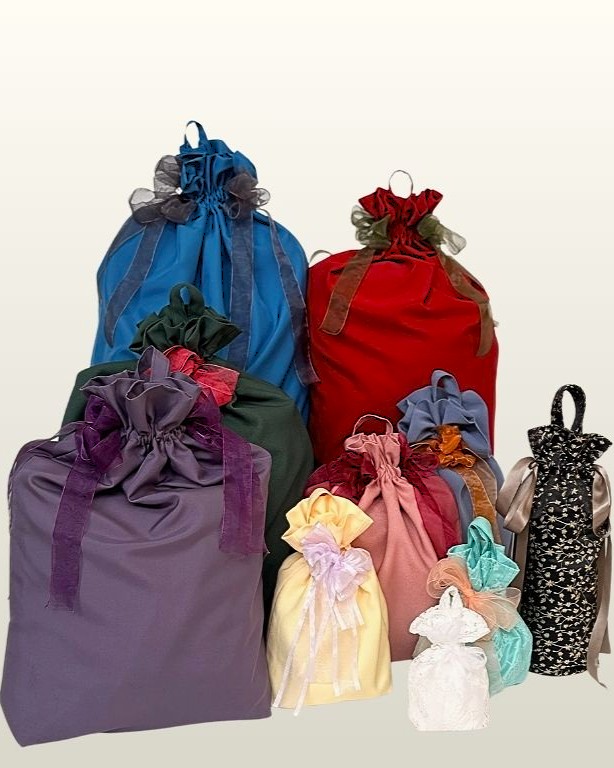 Ten reusable fabric gift bags in different sizes with bow and ribbon closures, including wine bottle and cup bags, displayed on a plain light background. PDF sewing pattern for handmade gift bags in 10 sizes.